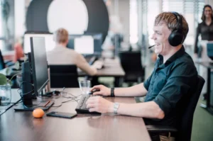 Meeting Expert met een headset op aan de telefoon zittend aan een bureau