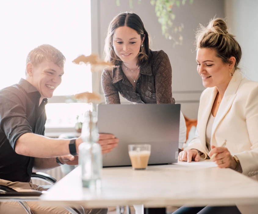 Drie collega's rondom een laptop